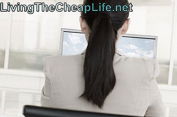 Bizneswomanu obsiadanie przed komputerem z chmurami i niebem na monitorze