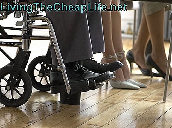 Sezione bassa di uomini e donne d'affari, uomo seduto su una sedia a rotelle