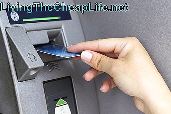Ręka kobiety wkłada kartę kredytową do bankomatu