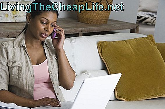 Γυναίκα συνεδρίαση στον καναπέ, ενώ στο κινητό τηλέφωνο και φορητό υπολογιστή
