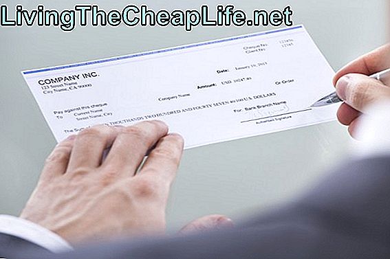 Empresário, assinando o cheque de dinheiro