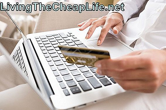 Kvinna som håller ett kreditkort och använder dator, handlar online